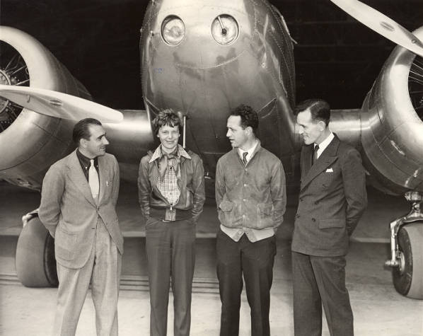 Amelia Earhart and her crew pose in front of the Electra. Left to right, Paul Mantz, co-pilot; Amelia Earhart, pilot; Captain Harry V. Manning, radio operator/navigator; and Captain Frederick J. Noonan, also a navigator, at Oakland Municipal Airport, California, 17 March 1937.