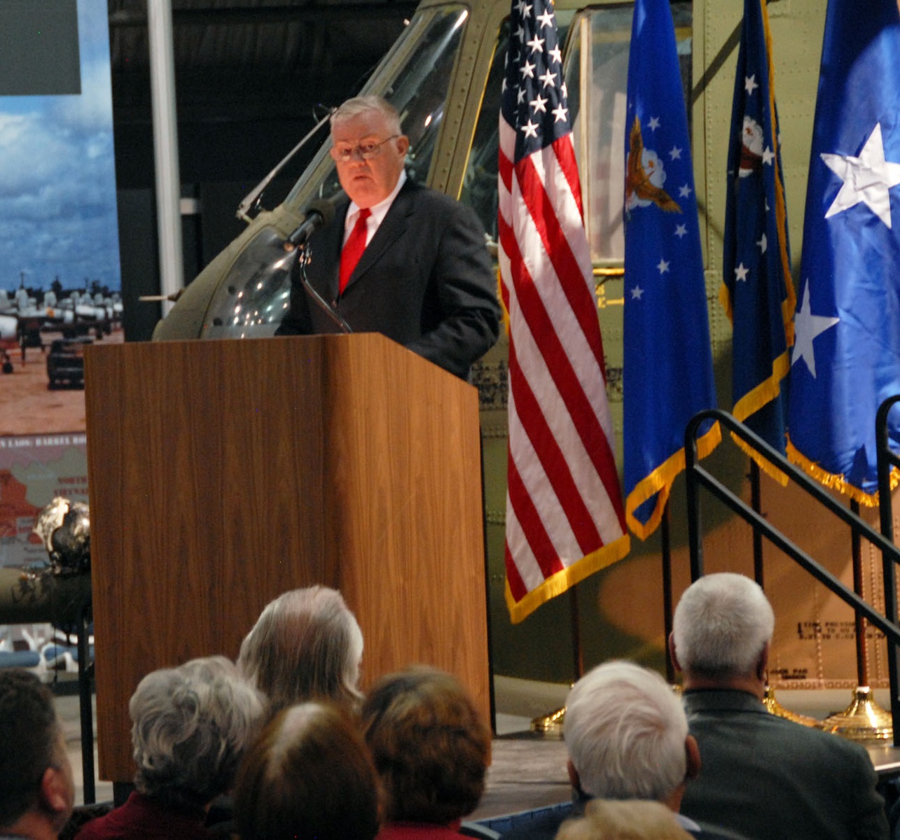 Mackay Trophy winner Colonel James E. McCardle, U.S. Air Force (Retired) speaks at the NMUSAF. His Jolly Green Giant, 67-14709, is behind him. (U.S. Air Force)