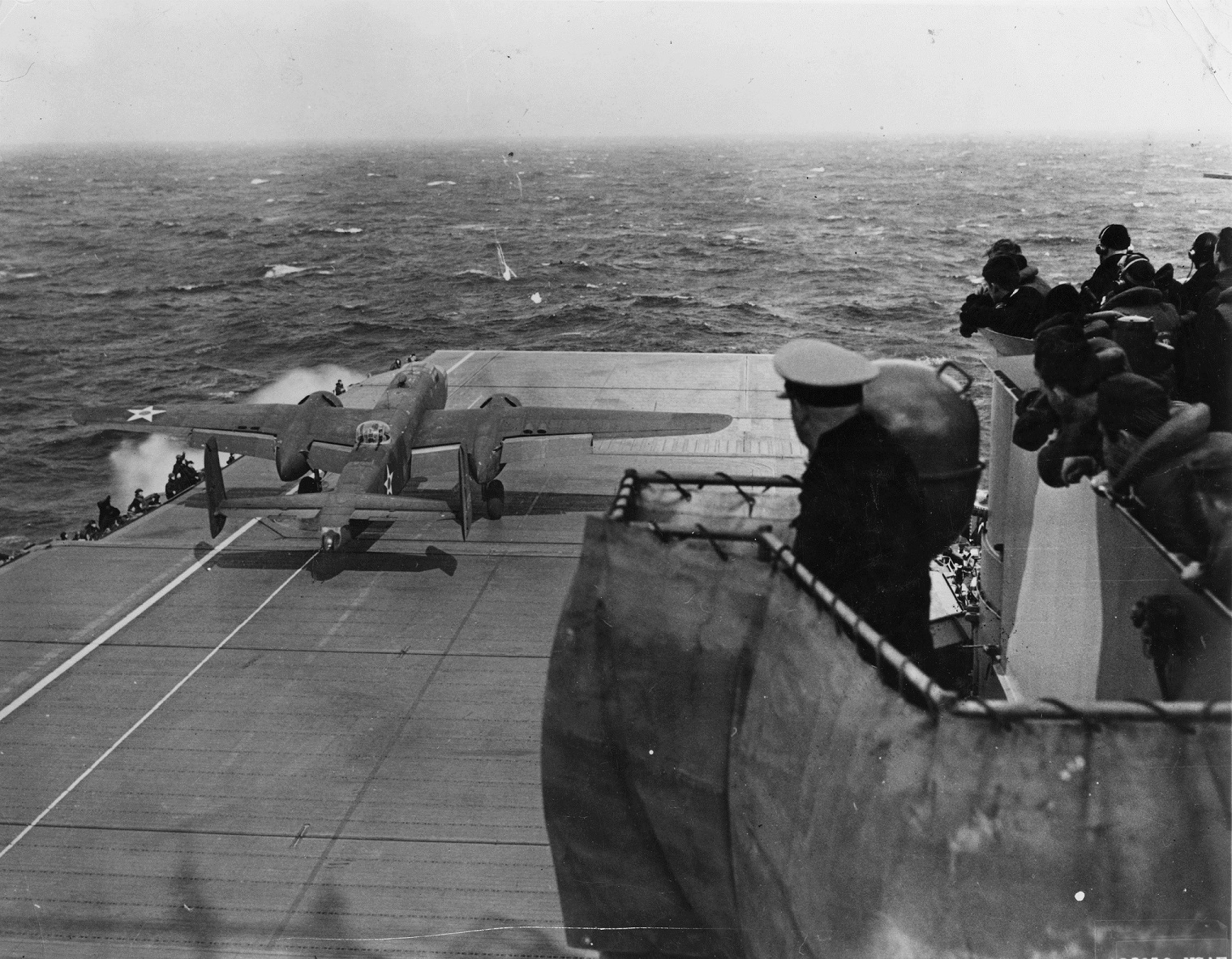 Admiral William H. Halsey watches a North American Aviation B-25B Mitchell medium bomber take off from USS Hornet (CV-8). The airplanes nose wheel has cleared the flight deck while the ship's bow pitches down in heavy seas. (U.S. Navy)