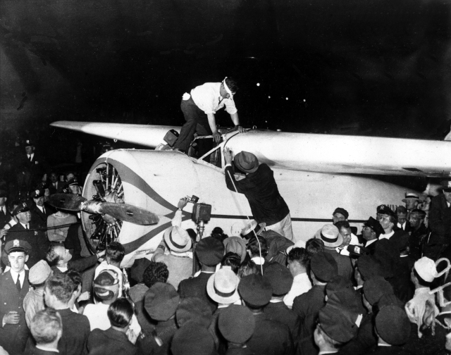 Wiley Post climbs out of the cockpit of his Lockheed Vega monoplane, Winnie Mae, after completing the first solo flight around the world at Floyd Bennet Field, Long Island, N.Y., midnight, July 22, 1933. Wiley set a new record with the distance of 15,596 miles, 25,099 kilometer, in 7 days, 18 hours, 49 minutes. (AP Photo)
