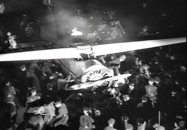 An estimated 50,000 spectators greet Wiley Post on his return to Floyd Bennett Field, 22 July 1933. Post is visible jut behind the trailing edge of the Vega's left wing. (Unattributed)
