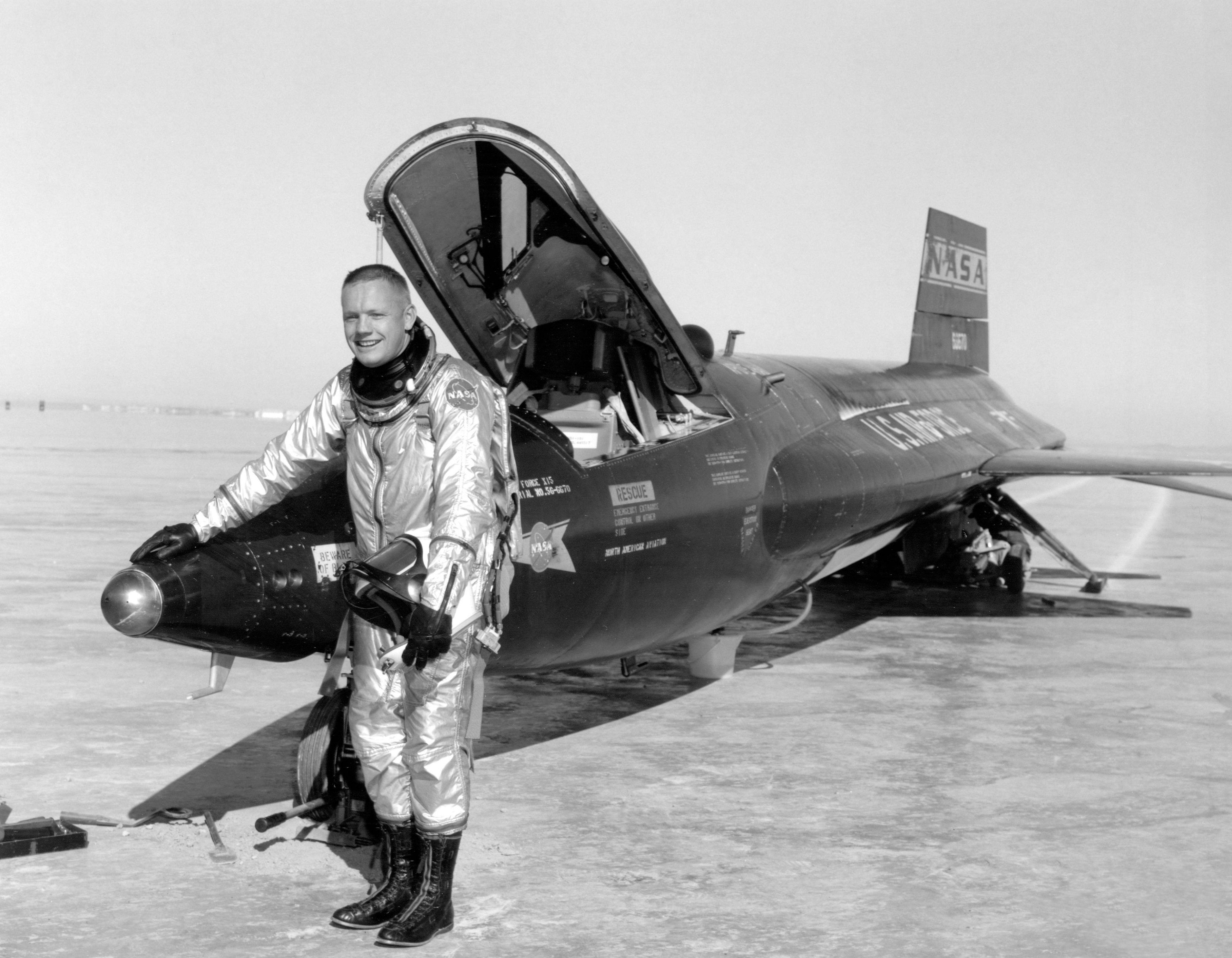 Neil Armstrong with the first North American Aviation X-15A, 56-6670, on Rogers Dry Lake after a flight, 1960. His hand is resting on the rocketplane's ball nose sensor. (NASA)