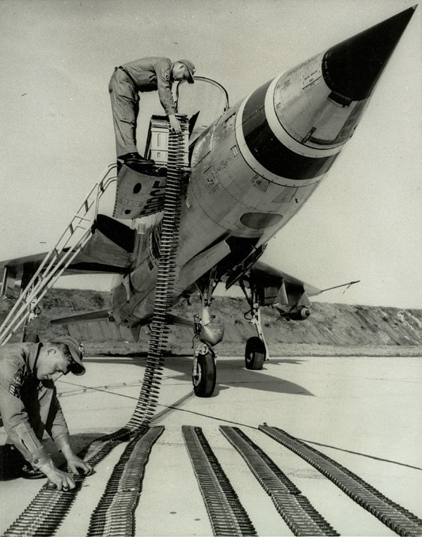 Two Air Force sergeants load belts of linked 20-millimeter cannon shells for the F-105's M61 six-barreled Gatling gun. (U.S. Air Force)