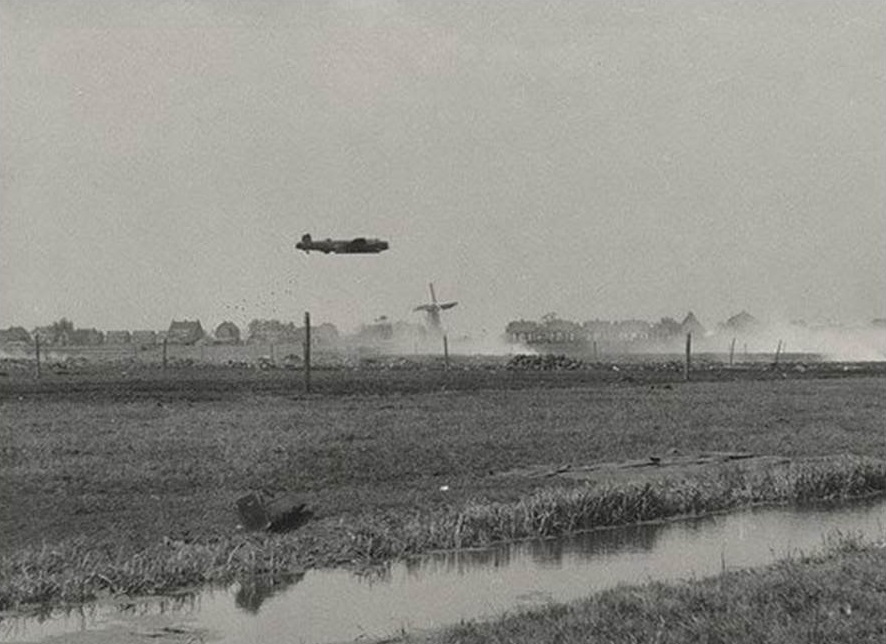 A Royal Air Force Avro Lancaster drops food packages from its bomb bay while flying at very low level over The Netherlands during Operation Manna.