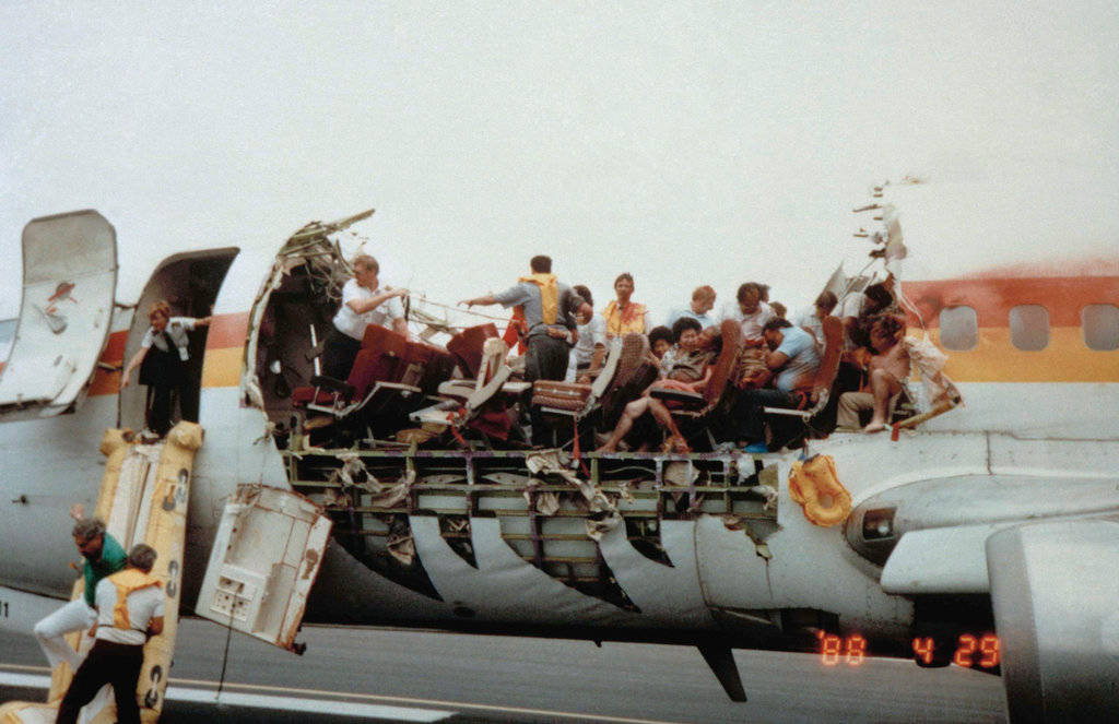Passengers and crew of Flight 243 begin to evacuate the damaged airliner at Kahalui Airport, Maui. (Unattributed)