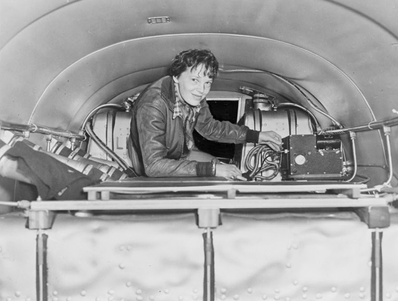 Amelia Earhart stands behind the additional fuel tanks installed in the aft cabin of her Electra. (AP)
