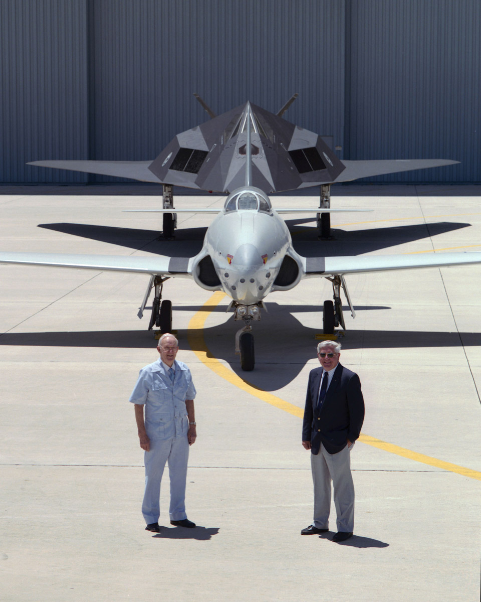 Lockheed test pilots Anthony W. ("Tony") LeVier and David L. Ferguson stand in front of P-80A 44-85123 and an F-117A Nighthawk at the Lockheed Skunk Works, Palmdale, California, 17 June 1993. (Denny Lombard, Lockheed Martin)