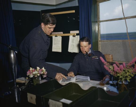 Wing Commander Guy Gibson at his desk with Squadron Leader D J H 'Dave' Maltby, one of his flight commanders. (Imperial War museum TR 1122)