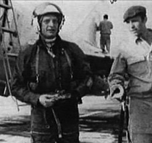Vladimir Sergeyevich Ilyushin, wearing flight suit and helmet, with a Sukhoi Su-9 in the background.