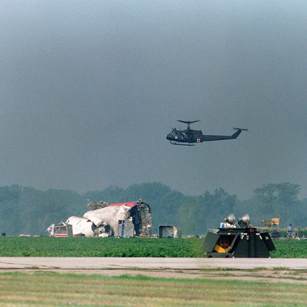 An iowa National Guard UH-1 medevac helicopter hovers over the wreckage of the United DC-10.