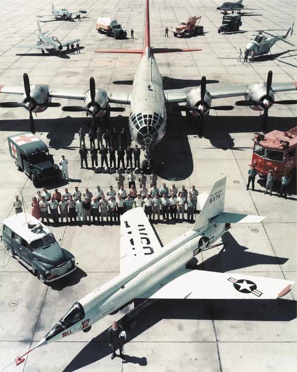 Iven Kincheloe stands in front of the Bell X-2 and the entire support team at Edwards Air Force Base. The "mothership" is a highly-modified Boeing EB-50D Superfortress. Chase aircraft are a North American F-86 Sabre, Lockheed T-33 Shooting Star, North American F-100 Super Sabre. The rescue helicopter is a Sikorsky H-19. 