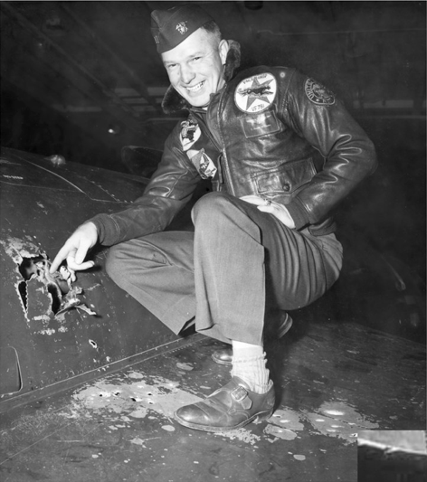 Lt. Royce Williams, USN, points out battle damage to his Grumman F9F-5 Panther, aboard USS Oriskany (CVA-34), 18 November 1952. (U.S. Navy)