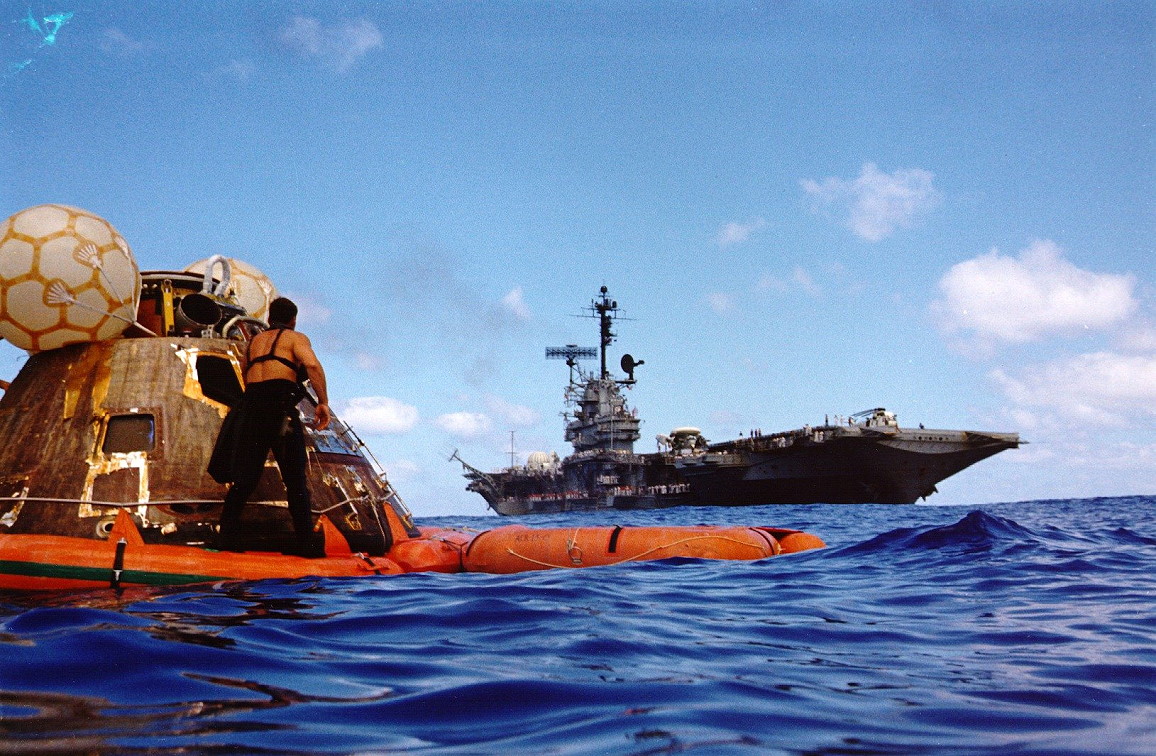 USS Ticonderoga (CVS-14) slowly approaches the Apollo 17 command module. Rescue swimmers have attached a flotation collar as a safety measure. (NASA)