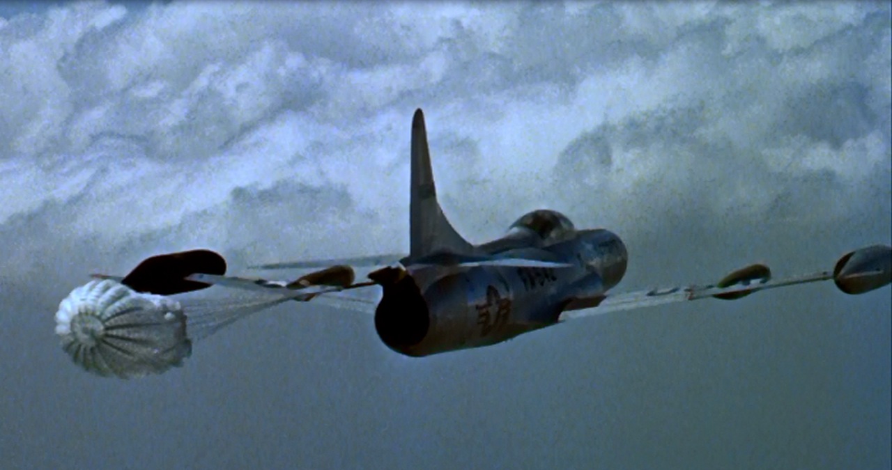 In this scene from the motion picture "Toward The Unknown" (Toluca Productions, 1956) which starred William Holden and Lloyd Nolan in a story about test pilots at Edwards Air Force Base, a Lockheed F-94C Starfire has released a drag chute in flight, simulating Captain Richard Harer's test flight of 22, December 1954.