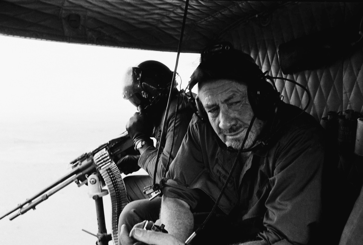Author John Steinbeck observes the Vietnam War from a U.S. Army UH-1B "Huey" helicopter. A gunner mans an M60 7.62mm machine gun. (Associated Press)