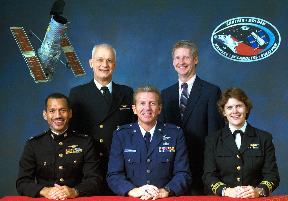 Discovery (STS-31) flight crew: Seated, left to right: Colonel Charles F. Bolden, Jr., U.S. Marine Corps; Colonel Loren J. Shriver, U.S. Air Force; Lieutenant Commander Kathryn D. Sullivan, U.S. Navy. Standing, left to right: Captain Bruce McCandless II, U.S. Navy; Mr. Steven A. Hawley. (NASA)
