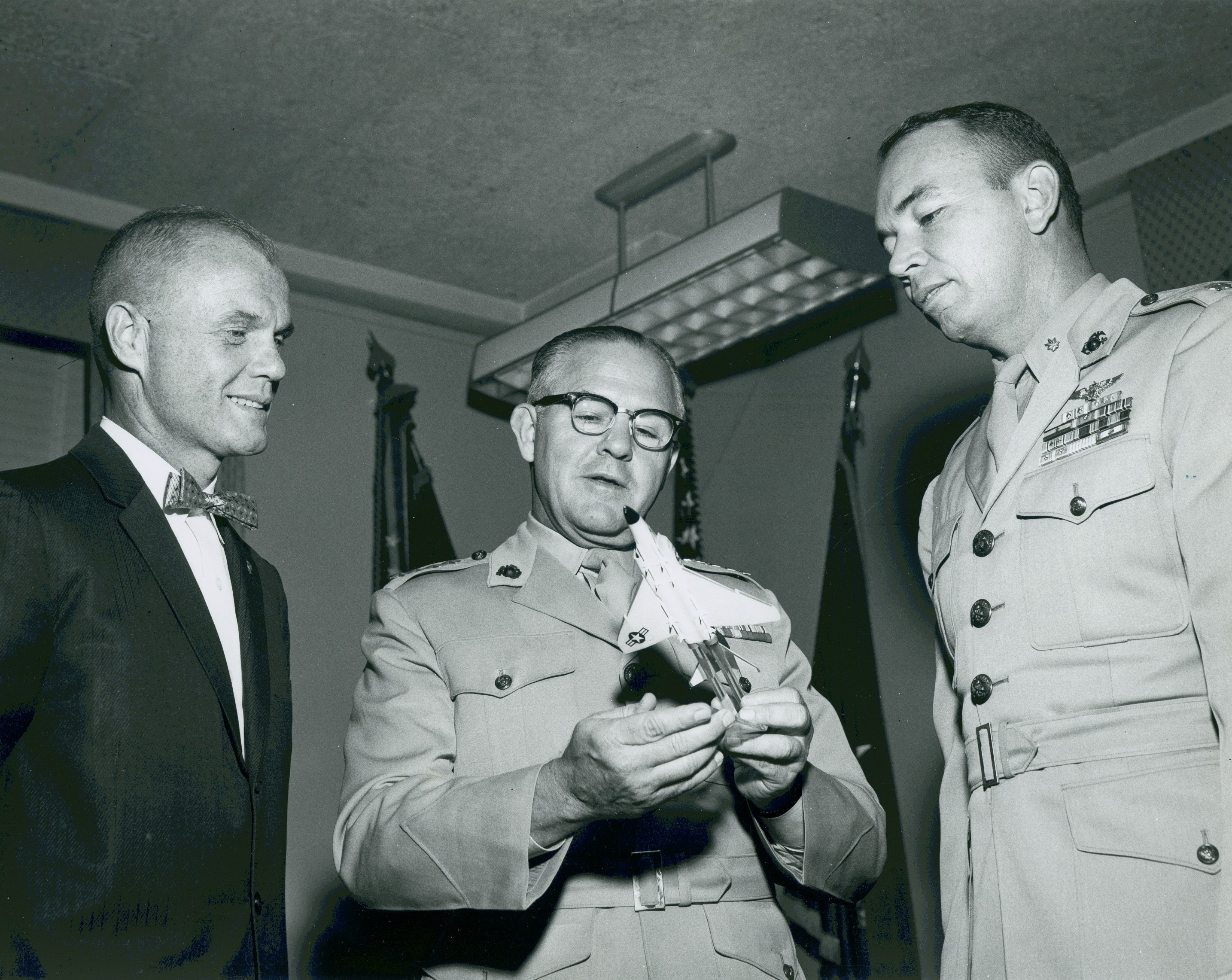 John H. Glenn, Jr., General David M. Shoup, Commandant of the Marine Corps and Lieutenant Colonel Thomas H. Miller Jr., at Marine Corps Headquarters, 15 September 1960. General Shoup holds a scale model of the McDonnell F4H Phantom II. (Photograph Collection (COLL/3948), Marine Corps Archives & Special Collections)