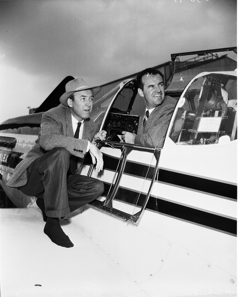 Jimmy Stewart crouches on Mr. Alex' wing, while Joe De Bona occupies the cockpit. (Unattributed)