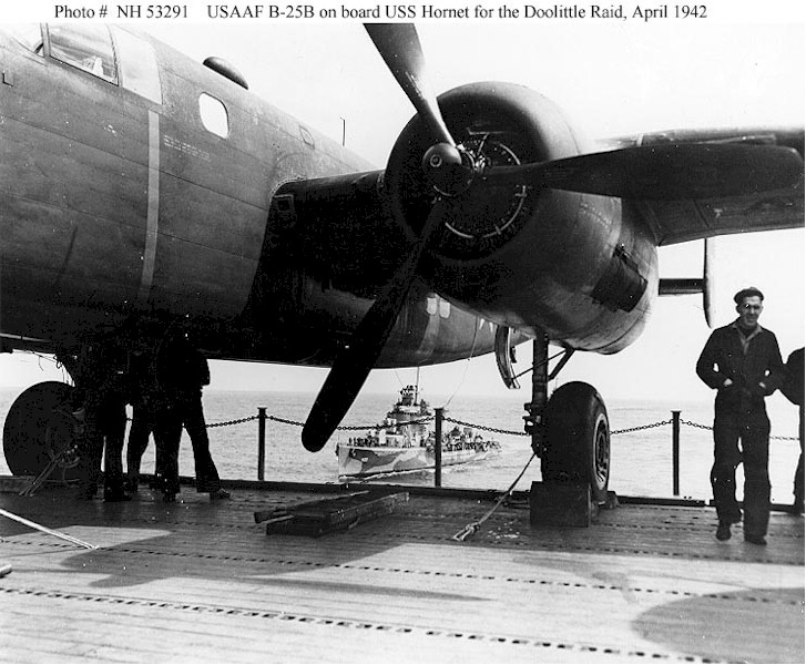North American Aviation B-25B Mitchell medium bomber tied down on the flight deck of U.S.S. Hornet (CV-8). An escorting destroyer, USS Gwin, (DD- ) closes on the carrier's right rear quarter. (U.S. Navy)