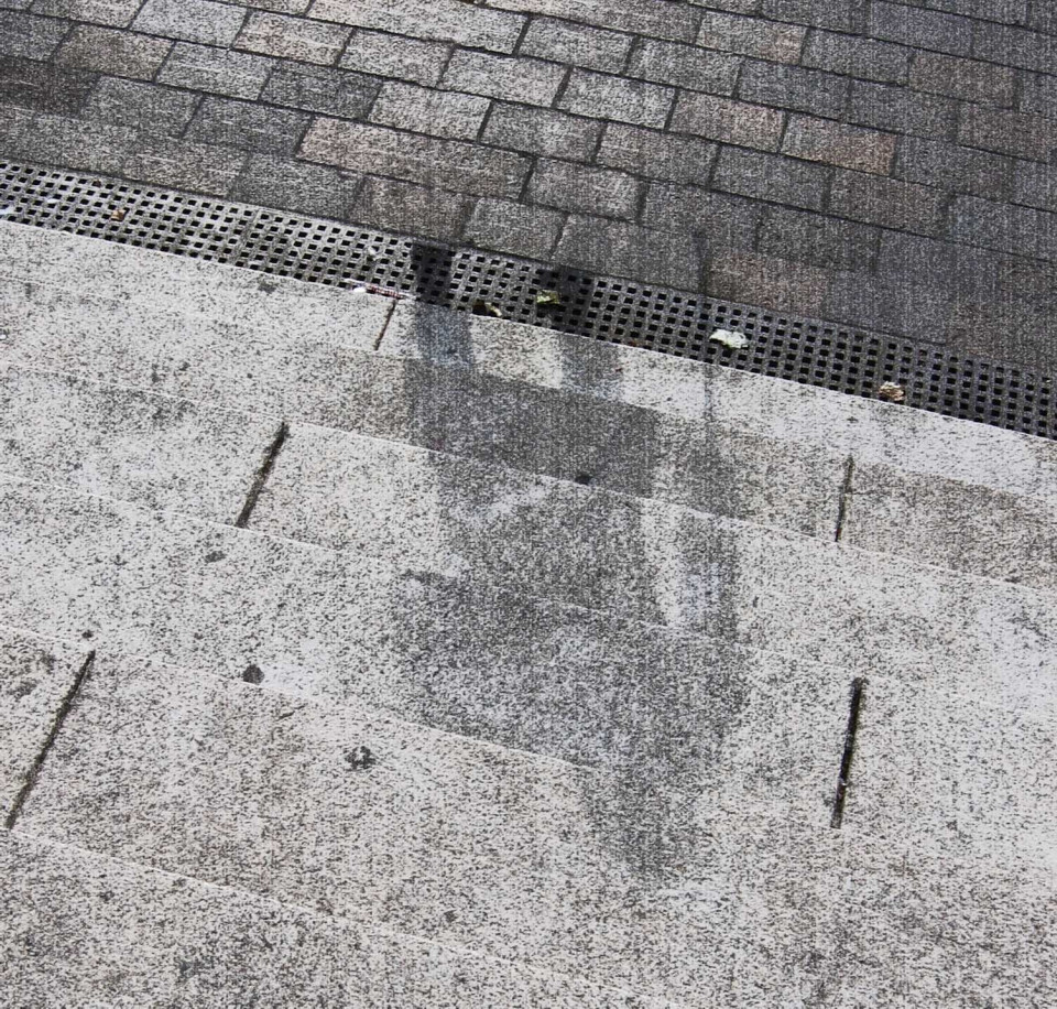 The shadow of one of the victims of the atomic bomb is etched onto the steps in front of a destroyed building.