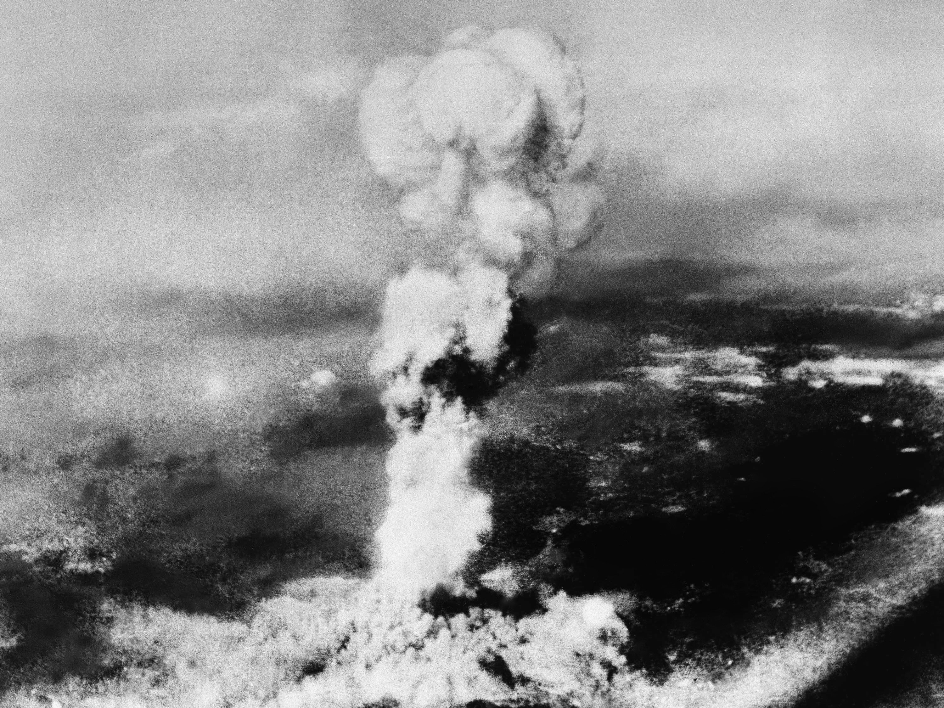 A mushroom cloud rises over the devastated city Hiroshima, Japan, 2–3 minutes after detonation, 6 August 1945, photographed by Technical Sergeant George R. Caron, U.S. Army Air Corps, tail gunner of the B-29 Enola Gay, using a Fairchild Camera and Instrument Company K-20 aerial camera with a 6-3/8" f/4.5, 4" × 5" film negative. (National Archives RG 77-AEC)