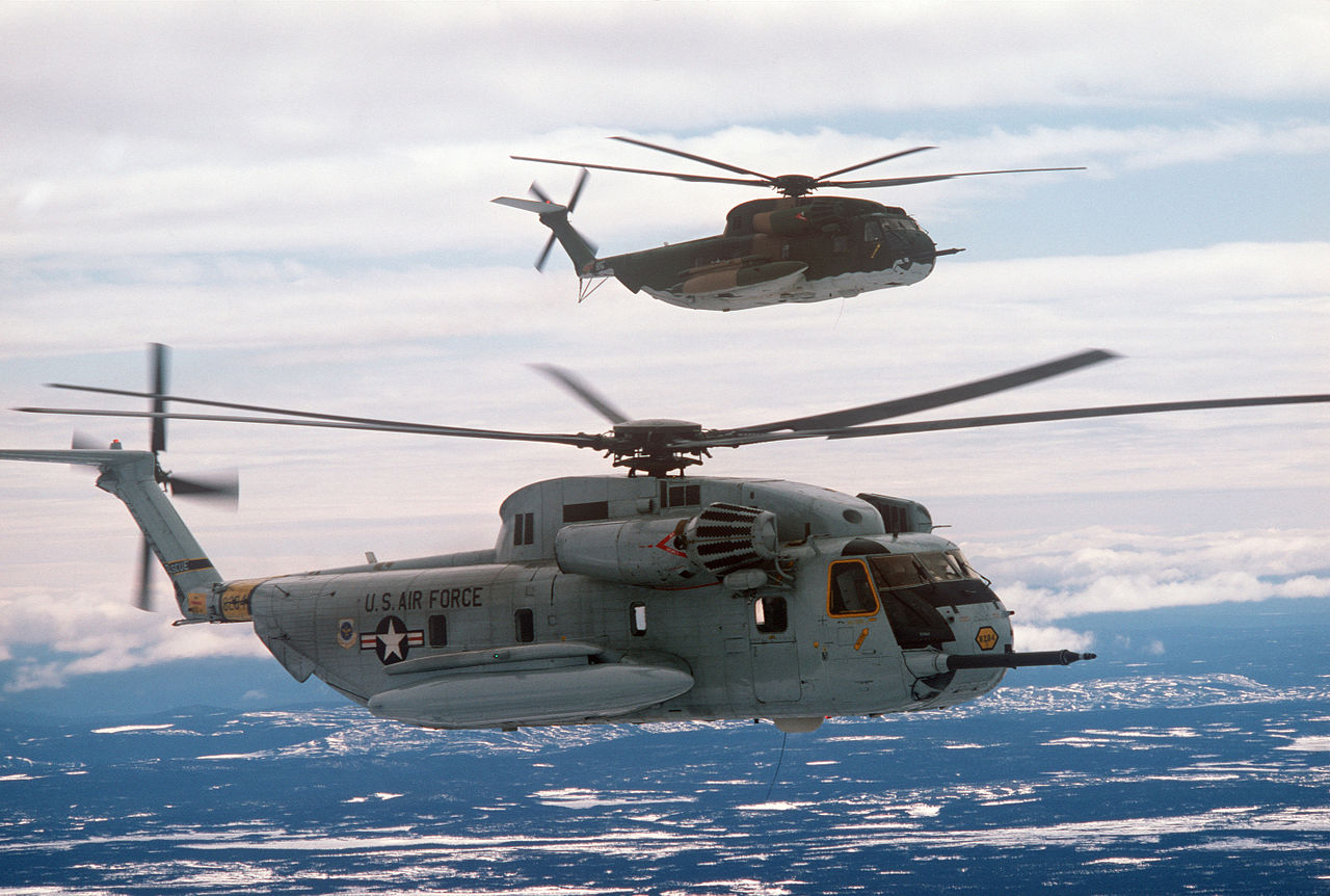 Two Sikorsky HH-53C Super Jolly Green Giants of the 39th Aerospace Rescue and Recovery Wing fly in formation over Goose Bay, Canada, 11 June 1978. 68-8284 is the ship closest to the camera, painted gray. (TSgt. Robert C. Leach/U.S. Air Force)