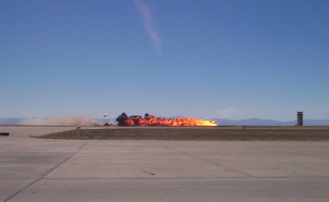 Captain Stricklin descends by parachute as his F-16 leaves a trail of fire on the runway at Mountain Home AFB. (Still frame from YouTube video at https://youtu.be/ujXnhCfrjX8 )