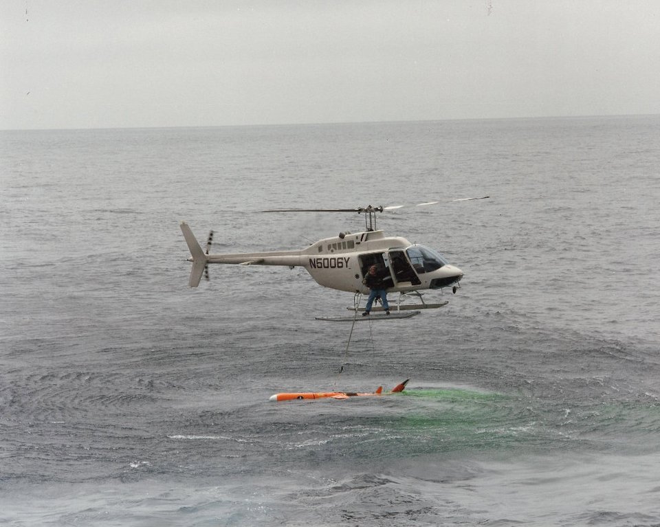 This photograph was taken from my helicopter while a talk a new pilot through a drone recovery in the Pacific Missile Test Range. During an actual recovery, we rarely found the ocean so calm. (U.S. Navy)