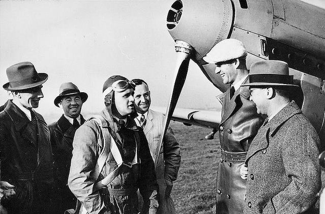 Dr. Ing. Hermann Wurster (left of center, wearing goggles, flight helmet and parachute) with the record-setting Bf 109 V13, D-KPKY. (AIRBUS)