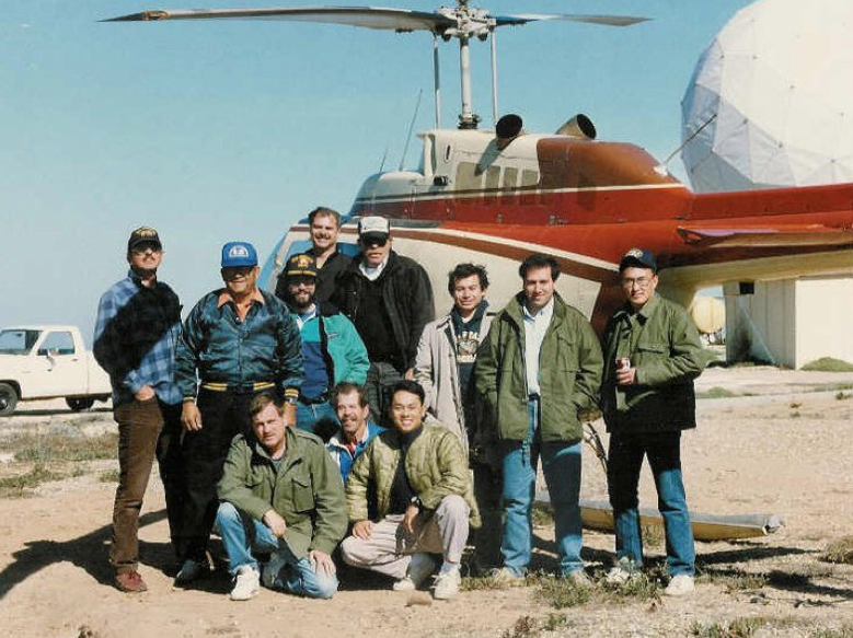 Jerry Boyle (back row, center with cap, sunglasses and black v-neck sweater) and I (slighty taller, to Jerry's right) with Gerneral Dynamics and Surface Targets technicians waiting for our next flight atop San Nicolas Island, offshore Southern California. (Autor's collection)