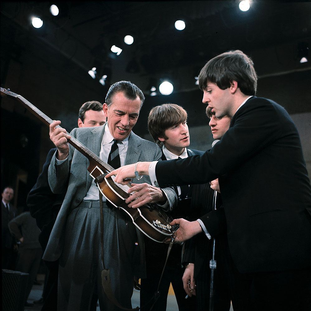 FILE - In this Feb. 9, 1964 file photo, Paul McCartney, right, shows his guitar to Ed Sullivan before the Beatles' live television appearance on "The Ed Sullivan Show" in New York. Behind Sullivan, from left, Beatles manager Brian Epstein, John Lennon, and Ringo Starr. CBS is planning a two-hour special on Feb. 9, 2014, to mark the 50th anniversary of the Beatles’ groundbreaking first appearance on “The Ed Sullivan Show.” (AP Photo, File)