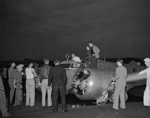 Paul Mantz, who was not aboard during the crash, stands in the Electra's cockpit. Amelia Earhart and Fred Noonan are standing on the wing, 20 March 1937. 
