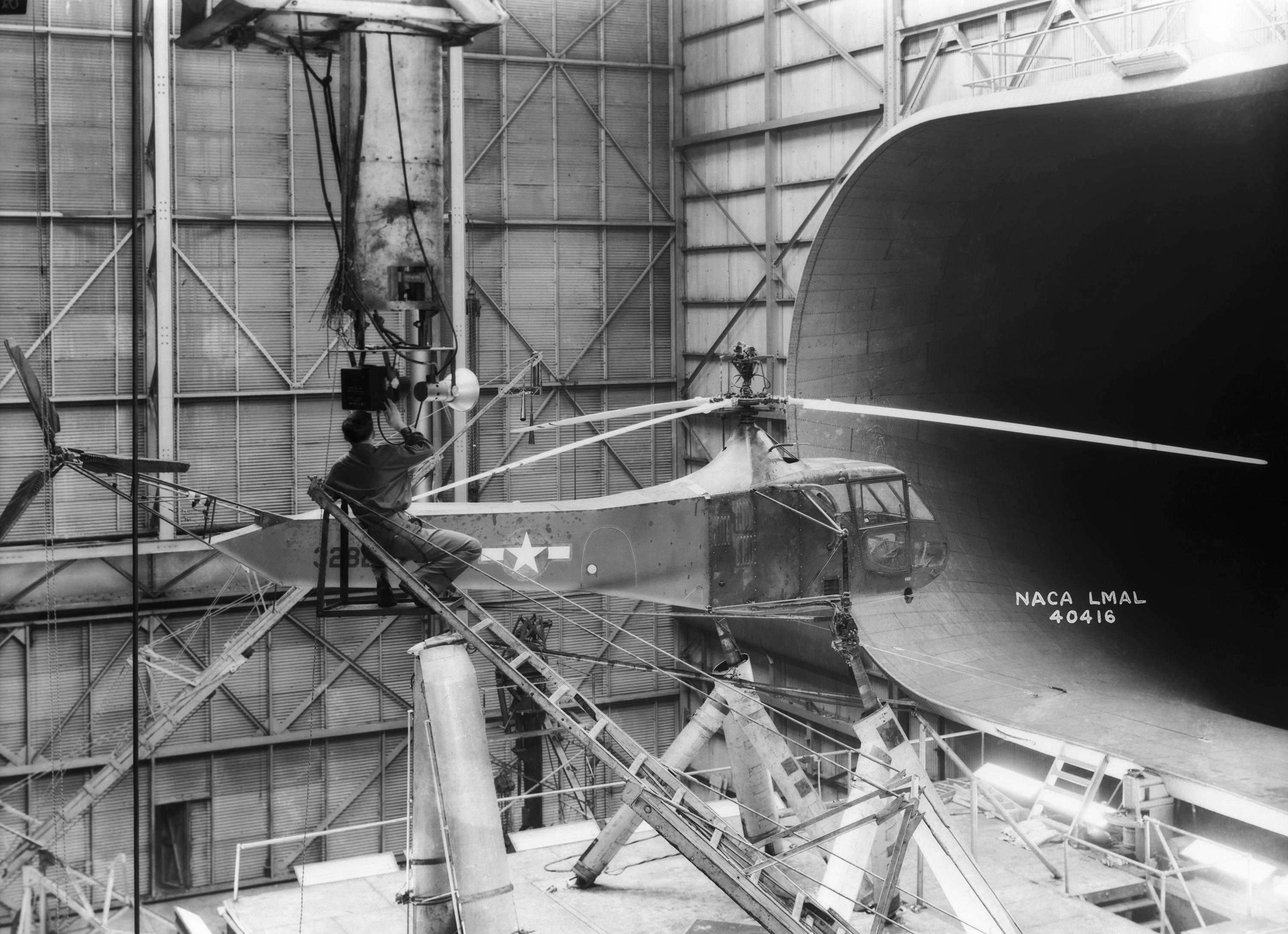 Sikorsky YR-4B 43-28225 in the NACA full scale wind tunnel, Langley Field, Virginia, 1944. A technician is preparing strobes to take stop-motion photographs of the helicopter's rotor blades while they turn at normal operating r.p.m. (NASA)