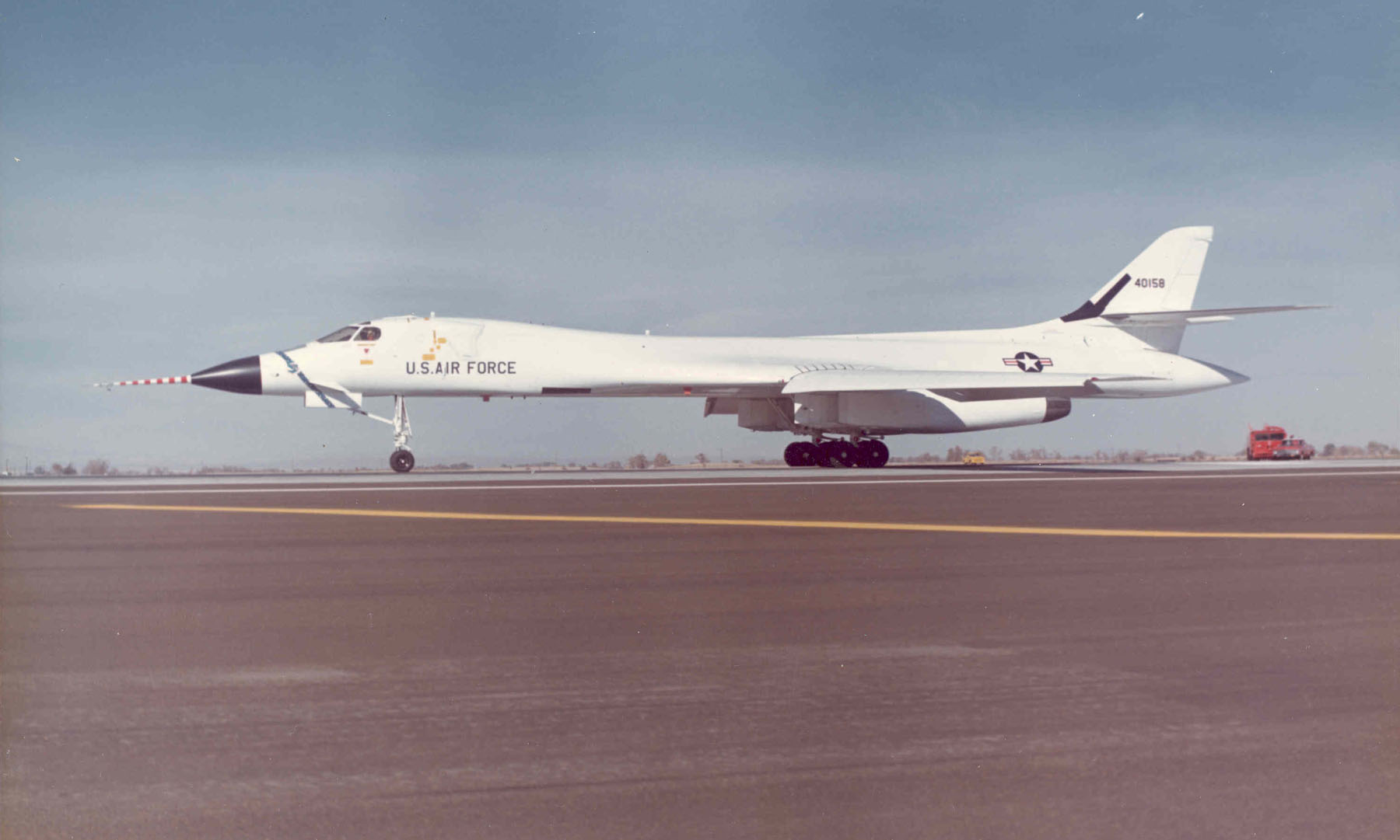 The first prototype Rockwell B-1A Lancer, 74-0158, at Edwards AFB. Visual differences of the B-1A that distinguish it from the later B-1B are the long drag link on the nose landing gear, the vertical inlet splitter vanes, black wheels and a long tail cone. On the upper fuselage behind the cockpit are the "elephant ears" intended to stabilize the crew escape capsule. (U.S. Air Force)