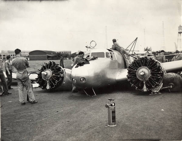 Amelia Earhart's heavily damaged Lockheed Electra 10E Special, NR16020, after a ground loop on takeoff at Luke Field, Hawaii, 20 March 1937. (Amelia Earhart stands in the cockpit of her unfinished Lockheed Electra 10E Special, serial number 1055, at the Lockheed Aircraft Company factory, Burbank, California, 1936. (Purdue University Libraries, Archives and Special Collections)