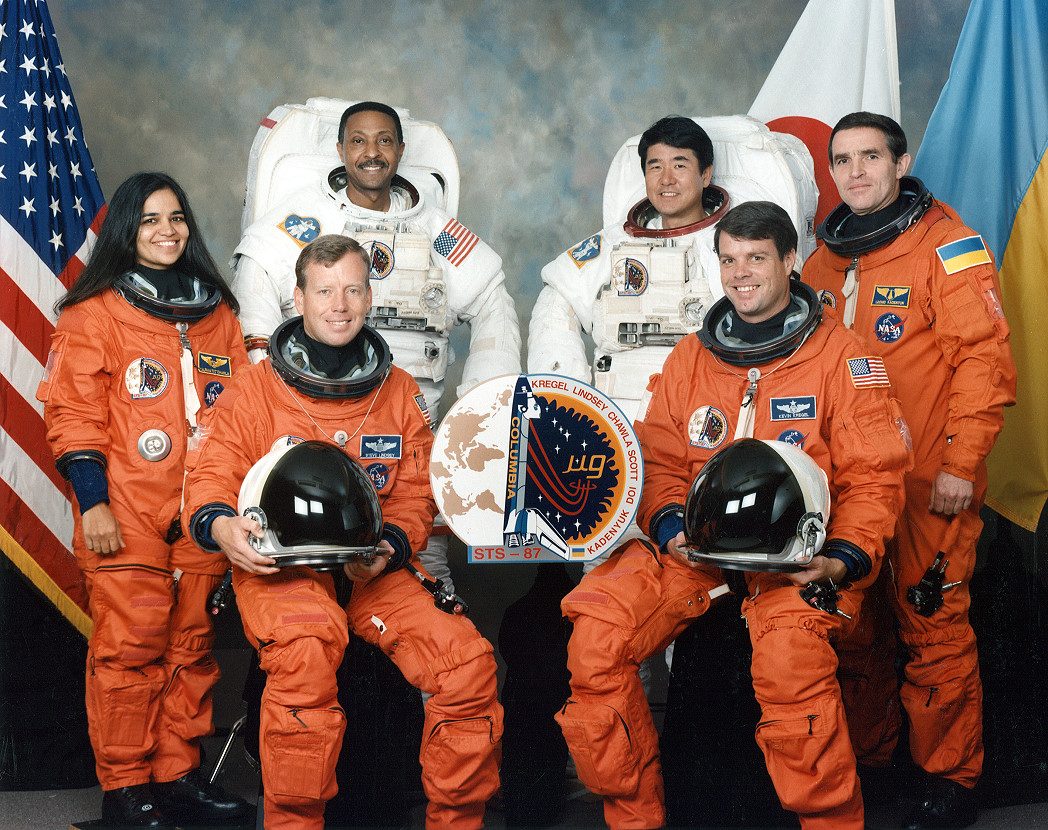 The flight crew of Columbia (STS-87): left to right, in orange: Dr. Kalapana Chawla; Colonel Steven W. Lindsey, USAF; Colonel Kevin R. Kregel, USAF; Major General Leonid K. Kadenyuk, UAF. In white, Captain Winston E. Scott, USN; Dr. Takao Doi, JAXA. (NASA) 