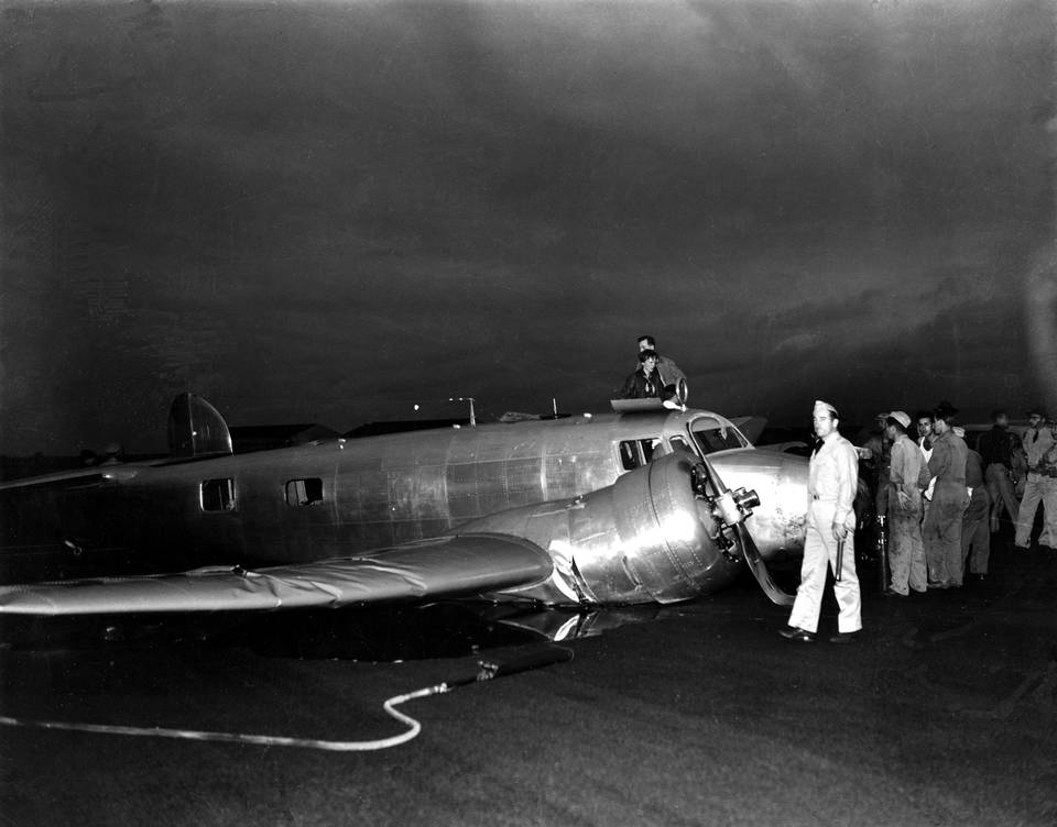 Amelia Earhart's damaged Lockheed Electra 10E, at Luke Field, Ford Island, 20 March 1937. Earhart is standing in the open cockpit hatch. (AP/Wichita Eagle)