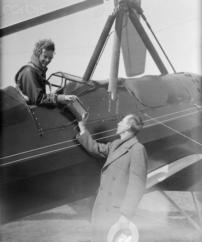 08 Apr 1931, Pennsylvania, USA --- Original caption: Miss Amelia Earhart in two altitude tests with an autogiro plane, at the Pitcairn Airfield, Willow Grove, Pa., soars to height of 18,500 feet in the first, and surpasses that mark by 500 feet in the second. If her barographs correspond with those marks, she in all probability will have established a world record for men as well as women. She is the only woman who ever piloted one of the "windmill" types of craft. Photo shows Amelia Earhart handing Major Luke Christopher, her barograph after her first flight. --- Image by © Bettmann/CORBIS