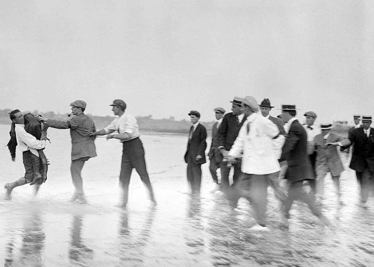 An unidentified man at the left of this photograph is carrying the body of Harriet Quimby.