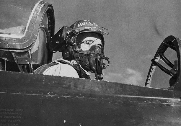 Lt. (j.g.) Huelsbeck in teh cocpit of a Grumman F9F. A small motion picture camera is attached to his flight helmet (Photograph courtesy of Neil Corbett, Test and Research Pilots, Flight Test Engineers)