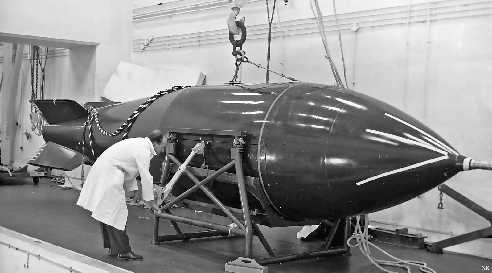 A technician gives a size reference to a Blue Danube bomb case. The same casing was used for the much more powerful Violet Club. (imgkid.com)