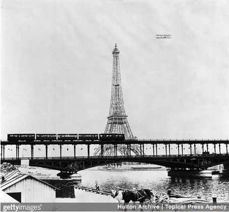 The Comte Charles de Lambert flies around the Eiffel Tower in Paris in his Wright aeroplane during his circular tour from Juvisy - Paris - Juvisy. (Photo by Topical Press Agency/Getty Images)