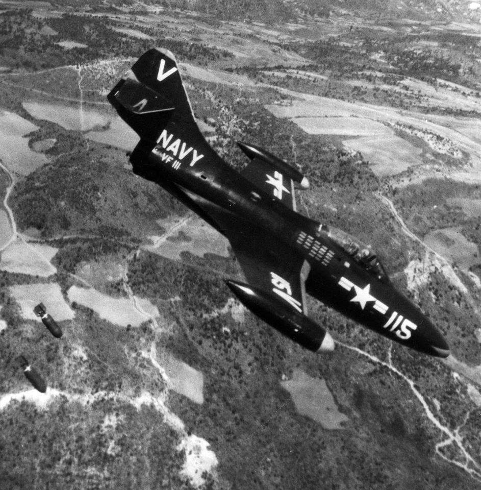 A Grumman F9F-2 Panther of Fighter Squadron 111 drops bombs over Korea, circa 1952. It is painted overall Glossy Sea Blue with red accents at the nose and tail. This is similar in appearance to the Panther flown by Lieutenant Commander William T. Amen, 9 November 1950. (U.S. Navy)