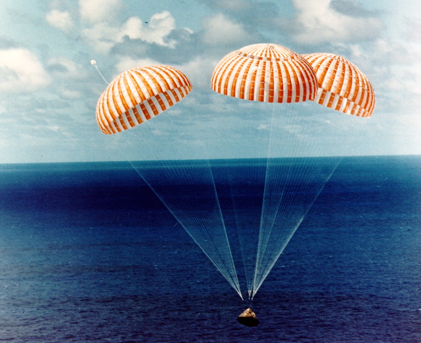 The Apollo 7 command module descends to the surface of the Atlantic Ocean under three parachutes, 22 October 1968. (NASA)