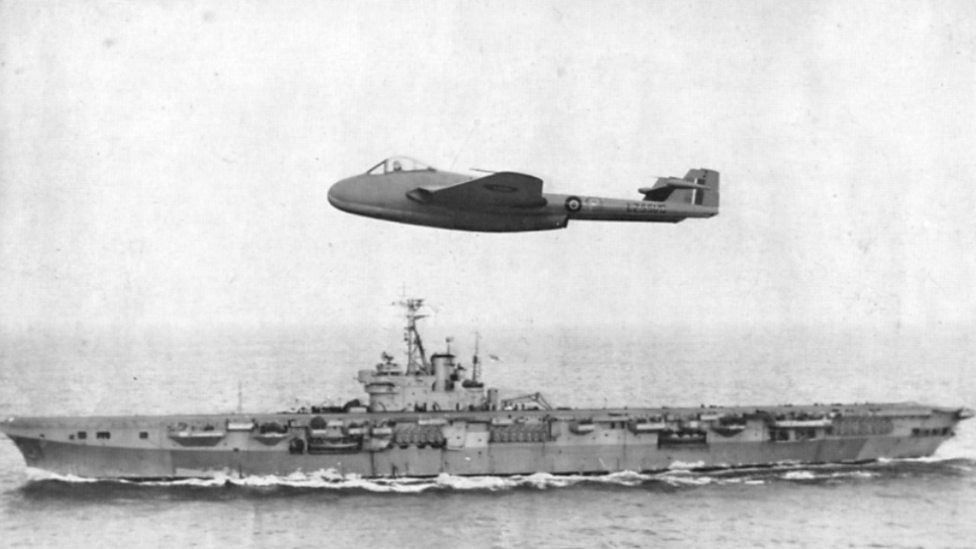 Winkle Brown and the DH.100 Sea Vampire fly past HMS Ocean.