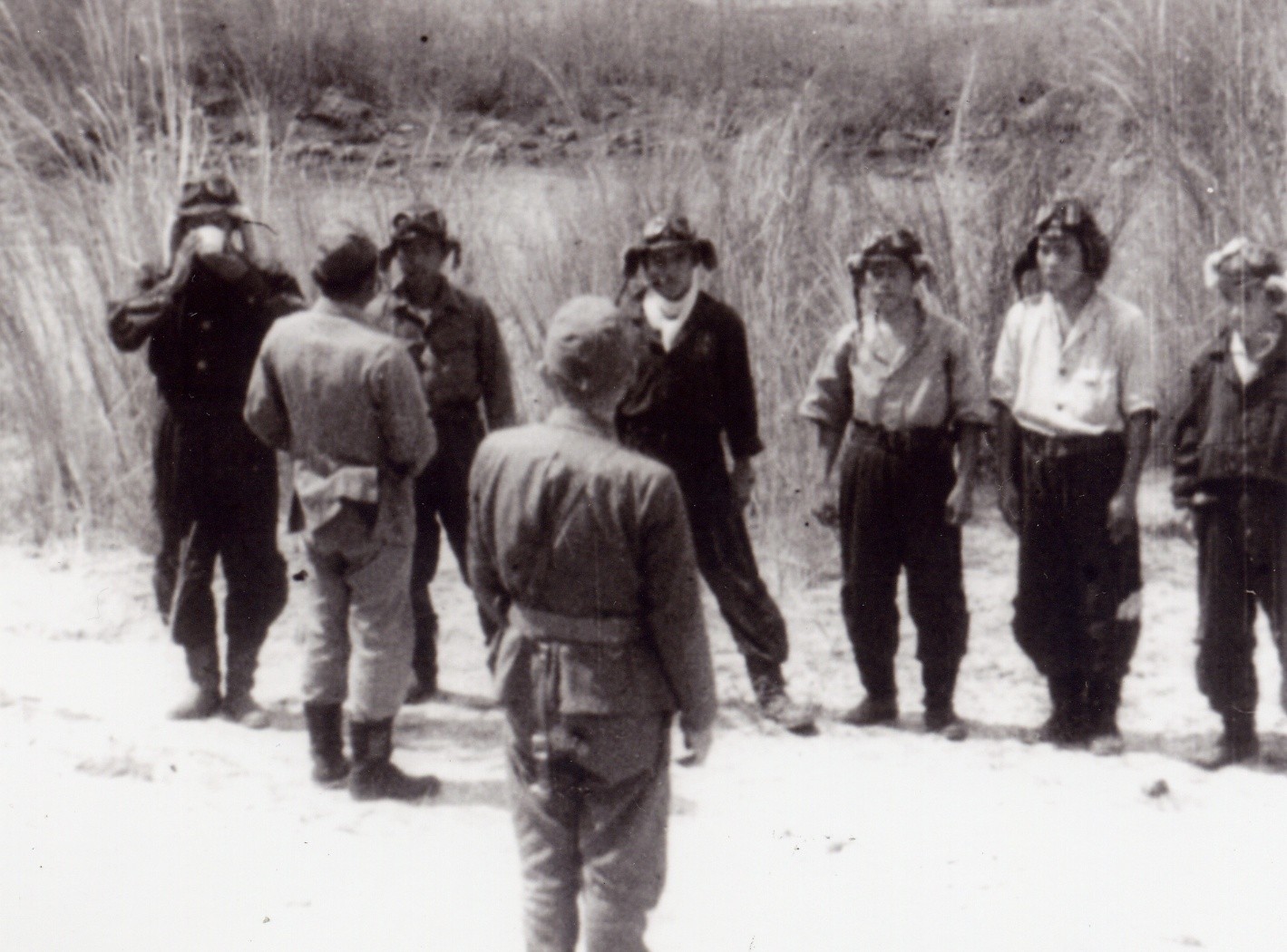 The Shikishima Kamikaze unit is offered a toast of water as a farewell, 25 October 1944. At left is Lieutenant Yukio Seki (with cup in his hands). Asaiki Tamai, with his back to the camera, is next to him. At center, also facing away from the camera, is Vice Admiral Takjiro Onishi.